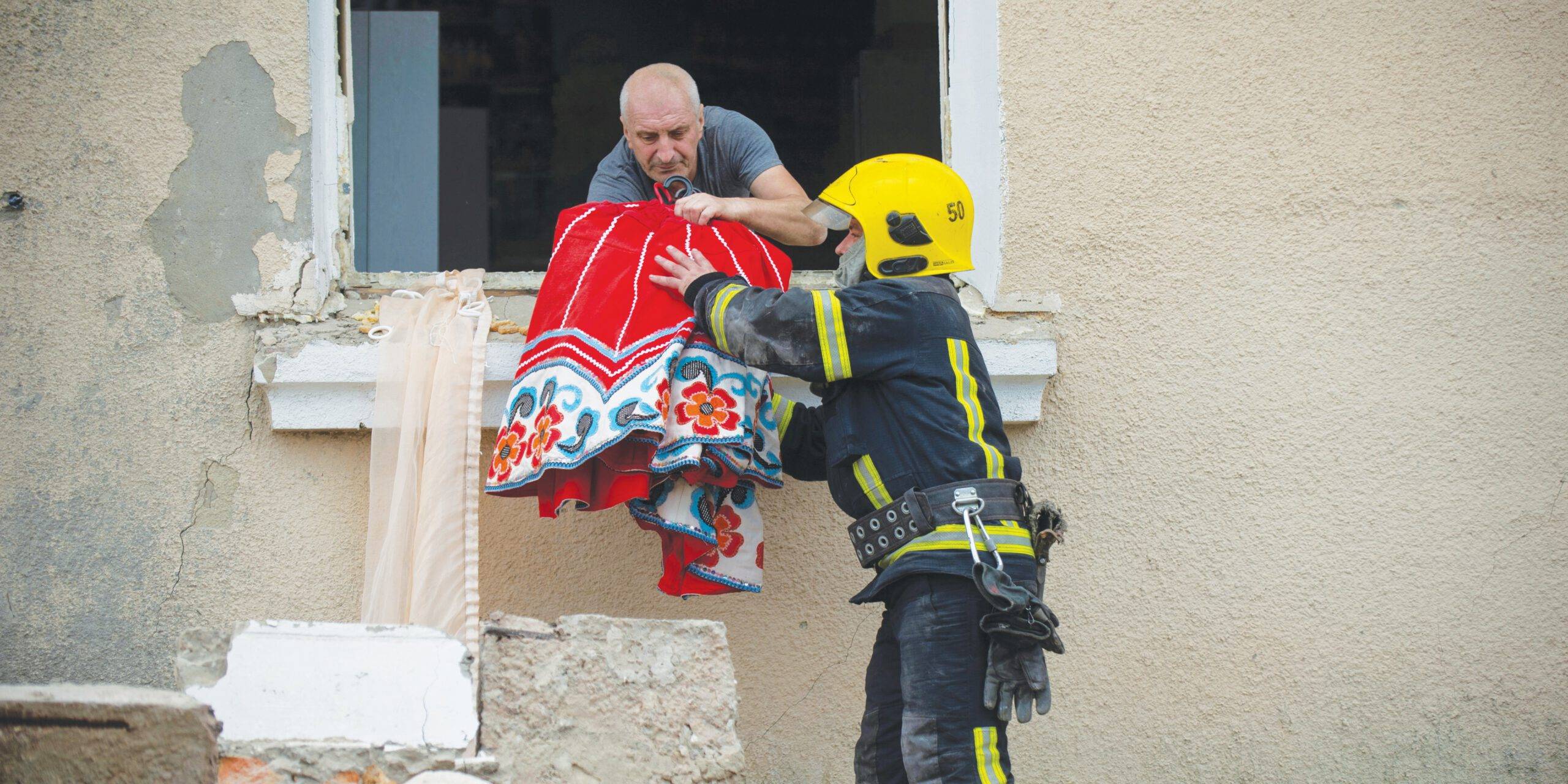 חייל אוקראיני מפנה אזרח אחרי הפגזה רוסית
